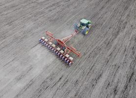 siembra de maíz. tractor con un sembradora en el campo. utilizando un sembradora para plantando maíz. foto