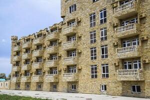 The hotel building, covered with decorative stone. Multi-storey hotel with a decorative trim, which is called Dagestani stone photo