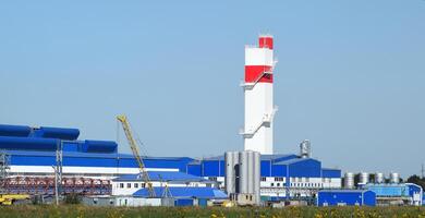 fuego torre a el planta para el Procesando de chatarra metal. enorme fábrica antiguo metal refinador foto