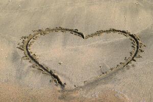Heart drawn on the beach sand photo