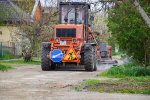 Grader on a dirt gravel road. Street repair by adding rubble. photo