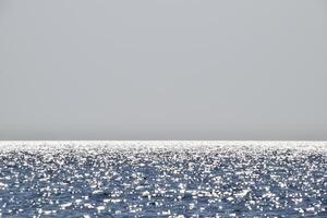 Sea line of the horizon. Sea and sky. The waves and glare of the sun are reflected from the waves of the sea. Seascape. photo