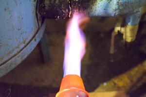 Heating a steel pipe with a blowtorch. The flame of a blowtorch photo