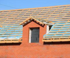 Construction of the roof of a new house. Wooden bars and vapor barrier photo