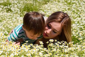 Woman with her son in a field of daisies. Family photo