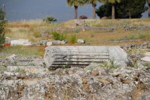 Elements of antique ruins of limestone blocks. The destroyed columns. Ruins of city of Hierapolis photo