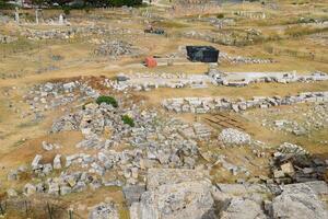 Top view of the excavation site in ruined ancient city of Hierapolis. The remains of destroyed buildings and columns. photo