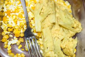 Breakfast of eggs, corn and broccoli in a container and with photo