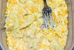 Breakfast of eggs, corn and broccoli in a container and with photo