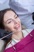 joven hembra paciente con bonito sonrisa examinando dental inspección a dentista clínica. sano dientes y medicamento, estomatología concepto foto