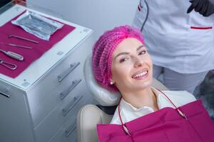 Beautiful woman with healthy straight white teeth sitting at dental chair with open mouth during a dental procedure. Dental clinic. Stomatology photo