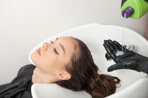 Hairdresser washing hair of a woman in a beauty salon photo