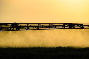 chorros de líquido fertilizante desde el tractor pulverizador. foto