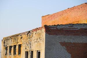 Old soviet brick abandoned building. Collapsing brick construction. photo