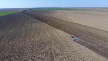 The tractor harrows the soil on the field for sowing photo