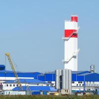 fuego torre a el planta para el Procesando de chatarra metal. enorme fábrica antiguo metal refinador foto