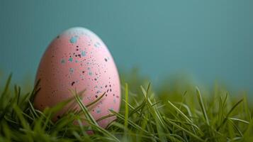 AI generated A minimalist Easter egg painted in pastel shades, resting on a bed of fresh green grass photo