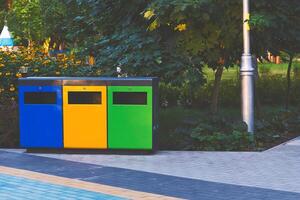 Ecology. Separate waste containers for plastic, paper and glass in a summer park photo