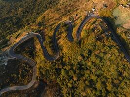 an aerial view of a winding road in the mountains photo