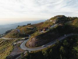 an aerial view of a winding road on a hillside photo