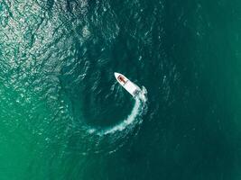 an aerial view of a boat traveling through the ocean photo