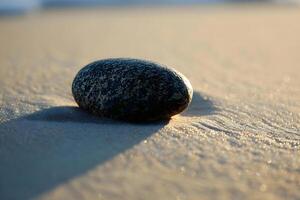 AI generated a rock sitting on top of a sandy beach photo