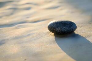 AI generated a rock sitting on top of a sandy beach photo