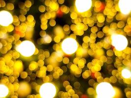 abstract bokeh blur light bubble circle red orange and white glowing flare pattern black background on christmas tree photo