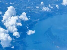 take picture on airplane high cloud on sky abstract outdoor white clouds and blue over ocean view town background in summer photo