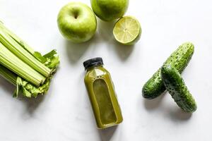 botella de verde zalamero con apio y manzana en blanco antecedentes foto