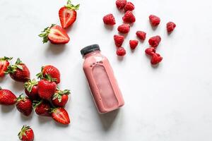 fresa zalamero en un botella con Fresco fresas en un blanco antecedentes foto