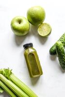 botella de verde zalamero con apio y manzana en blanco antecedentes foto