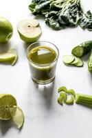 botella de verde zalamero con apio y manzana en blanco antecedentes foto