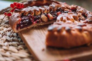 Fresh homemade pie with berries and nuts on a wooden board. Selective focus. photo