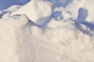 Lumps of snow in winter. Snow and light during the day. Snowdrifts. photo