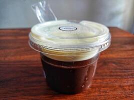 Chocolate pudding and milk in a cup on a wooden table photo