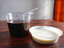 Chocolate pudding and milk in a cup on a wooden table photo