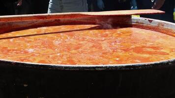 Tomato soup with pasta is a dish of Polish cuisine. Hot Zupa pomidorowa in a large cauldron at the field kitchen at a food fair. A popular soup made from grated tomatoes in their own juice. video