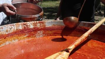 Tomato soup with pasta is a dish of Polish cuisine. Hot Zupa pomidorowa in a large cauldron at the field kitchen at a food fair. A popular soup made from grated tomatoes in their own juice. video