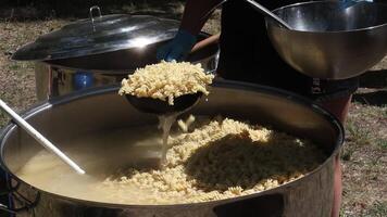 Tomato soup with pasta is a dish of Polish cuisine. Hot Zupa pomidorowa in a large cauldron at the field kitchen at a food fair. A popular soup made from grated tomatoes in their own juice. video