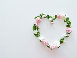Frame in form of heart from pink, white carnations photo