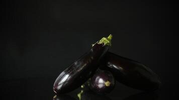 brut Frais mûr aubergines isolé sur noir Contexte video