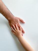 Adult and child hold their hands together. Fathers Day Child gives hand to adult photo