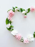 Frame in form of heart from pink, white carnations photo