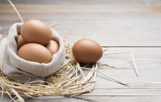 Fresh eggs from the farm placed on an old wooden table with copy space photo