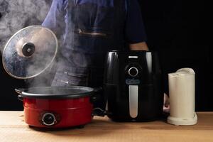 The chef's hand opens the lid of the hot soup pot. with smoke on a black background for people cooking and boiling water in kitchen photo