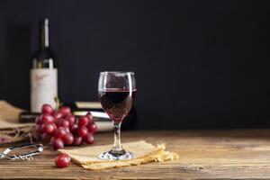 Red grape juice in a glass placed on a wooden table or red wine, a delicious natural healthy juice drink. With a bunch of fresh red grapes from the garden photo