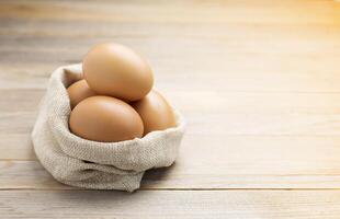 Fresh eggs from the farm placed on an old wooden table with copy space photo