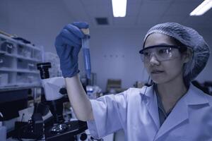 Asian scientist working in the lab,Researchers are research to find the results of the experiment,doctors are testing bloods to prevent and destroy new strains of the coronavirus through microscopy. photo