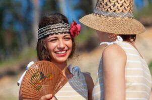 Two young women in retro swimsuits by the sea photo